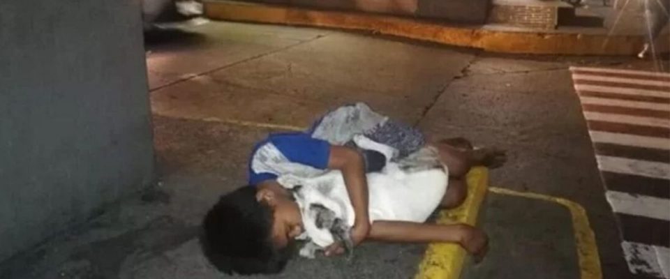 A foto do garoto que dorme na rua abraçando seu cachorro, sua única família